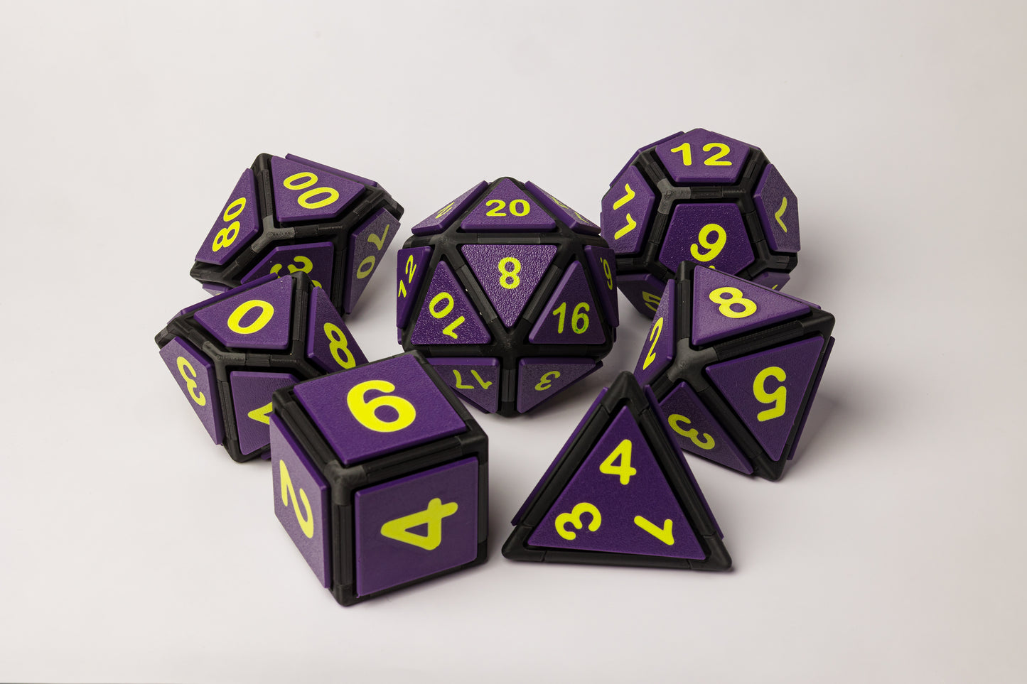 Set of purple and black polyhedral dice with neon green numbers on a white background